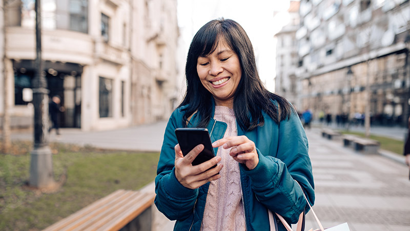 Person looking at screen while walking down the street